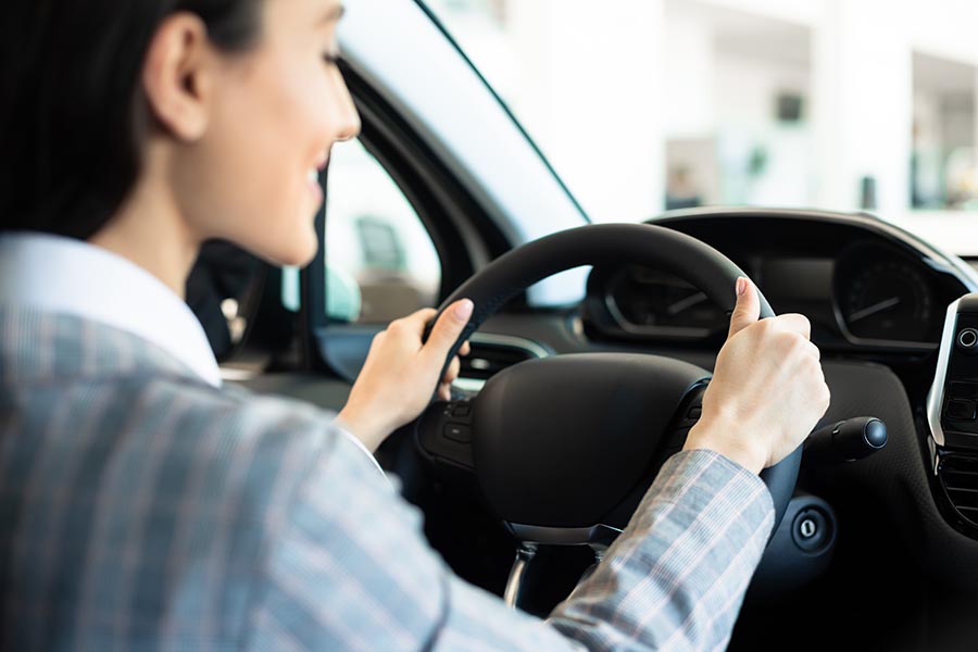 woman driving her car waiting for a vehicle inspection